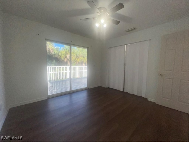 unfurnished bedroom featuring dark hardwood / wood-style floors, access to outside, ceiling fan, and a closet