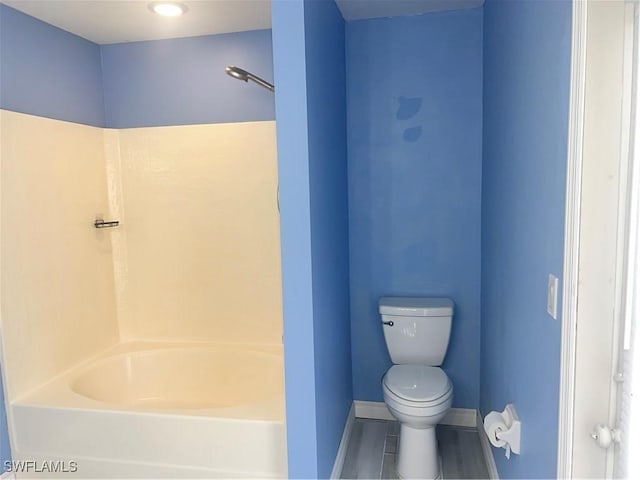 bathroom featuring shower / washtub combination and toilet