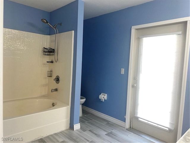 bathroom with bathing tub / shower combination and toilet