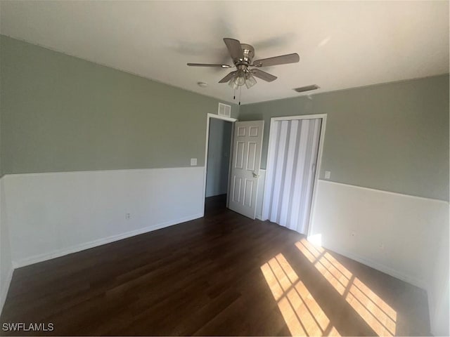 unfurnished bedroom with dark hardwood / wood-style floors, ceiling fan, and a closet