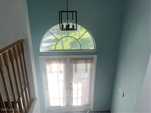 entryway with a chandelier, a healthy amount of sunlight, and french doors