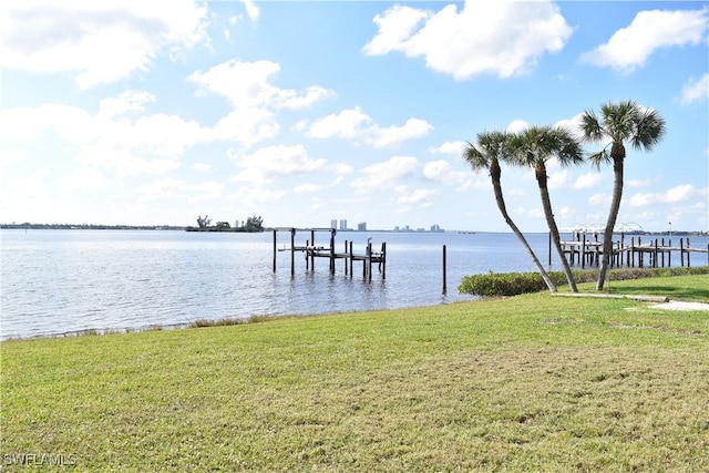 view of dock with a yard and a water view