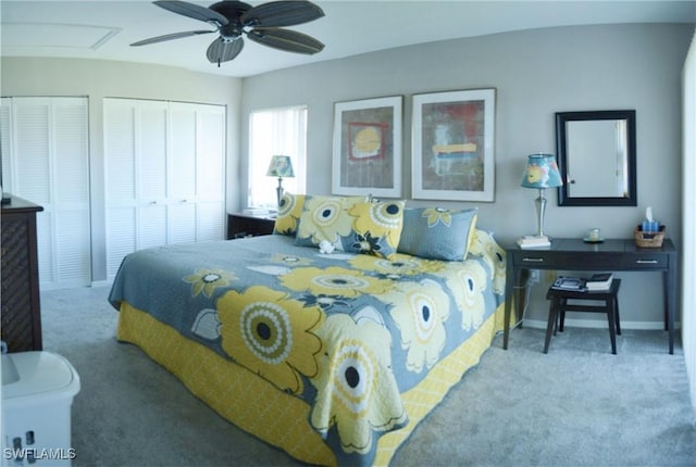 bedroom featuring ceiling fan, carpet floors, and multiple closets