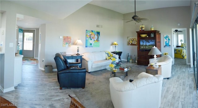 living room with ceiling fan, high vaulted ceiling, and light hardwood / wood-style flooring