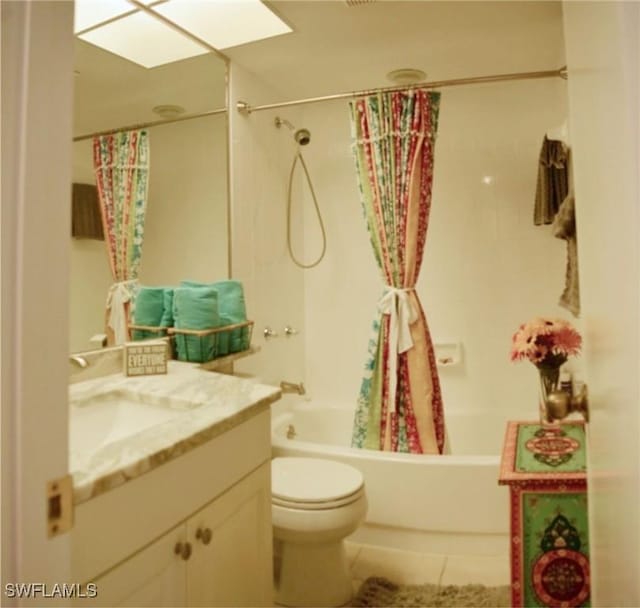 full bathroom with a skylight, tile patterned flooring, vanity, toilet, and shower / bath combo with shower curtain