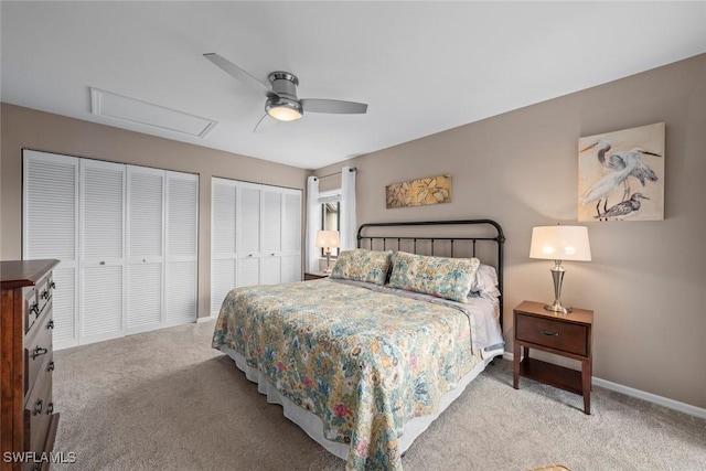 carpeted bedroom featuring ceiling fan and multiple closets