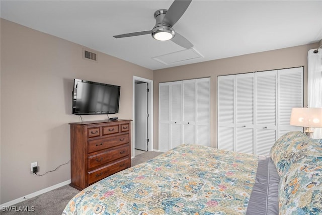 bedroom with two closets, light colored carpet, and ceiling fan