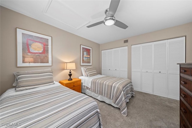 carpeted bedroom featuring two closets and ceiling fan