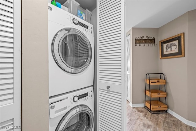 clothes washing area with stacked washer / dryer and light hardwood / wood-style floors