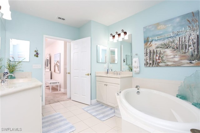 bathroom featuring tile patterned flooring, vanity, and a relaxing tiled tub