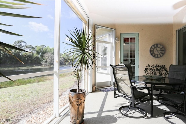 sunroom / solarium featuring a water view