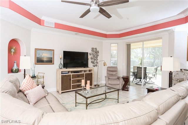 living room with crown molding, ceiling fan, a tray ceiling, and light tile patterned floors