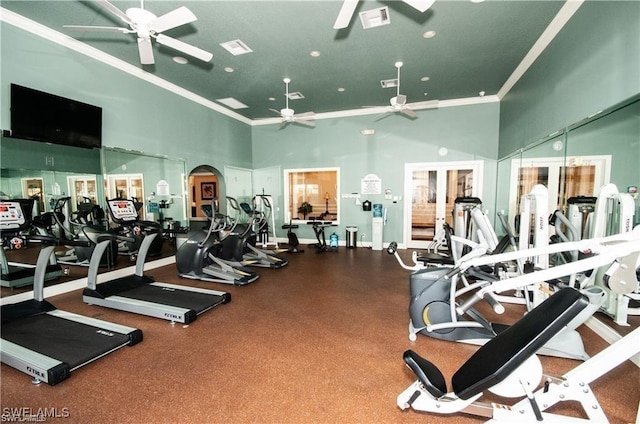 workout area featuring a towering ceiling, ornamental molding, and ceiling fan