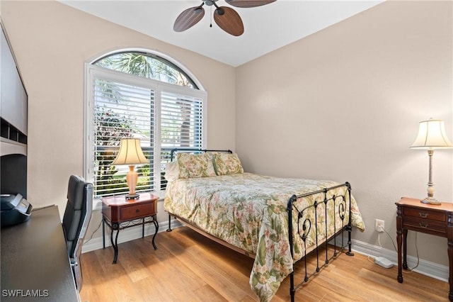 bedroom with ceiling fan, baseboards, and wood finished floors