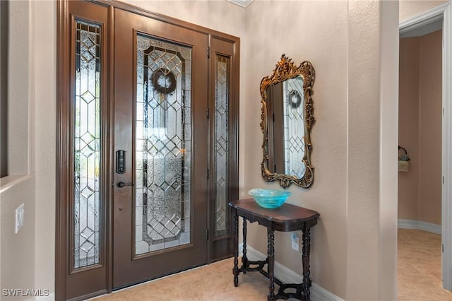 tiled foyer featuring baseboards