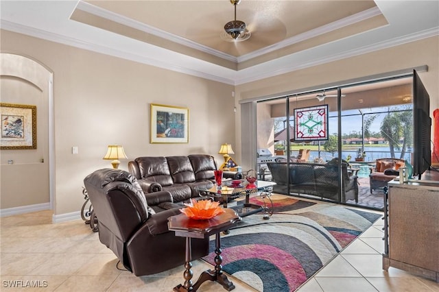 living room featuring light tile patterned floors, baseboards, a raised ceiling, ceiling fan, and crown molding