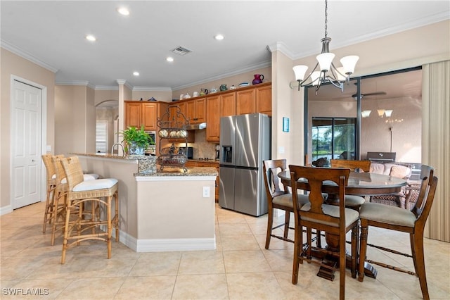 kitchen featuring a chandelier, visible vents, ornamental molding, brown cabinets, and stainless steel fridge