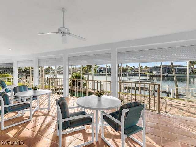 sunroom with a water view and ceiling fan