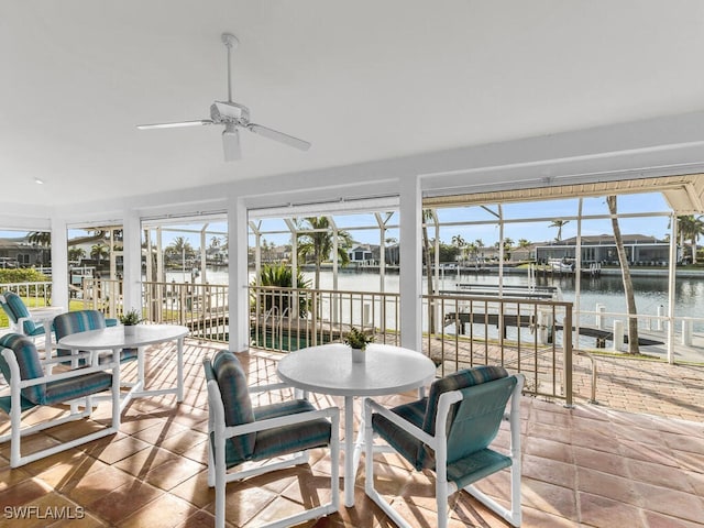 sunroom / solarium with a water view and ceiling fan