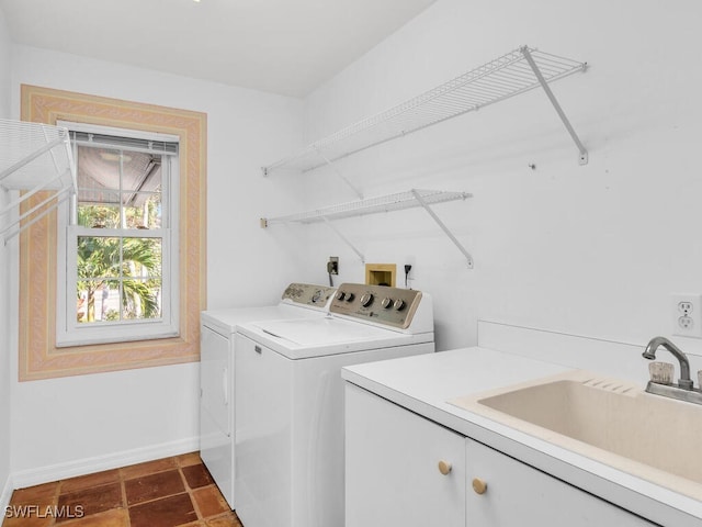 clothes washing area featuring cabinets, washer and clothes dryer, and sink