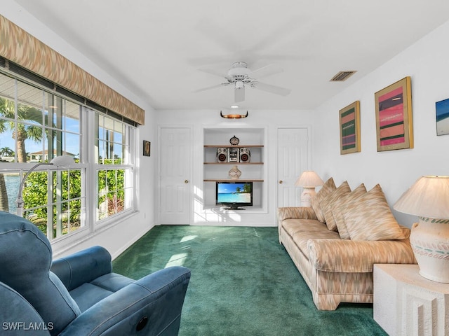 living room featuring dark carpet and ceiling fan