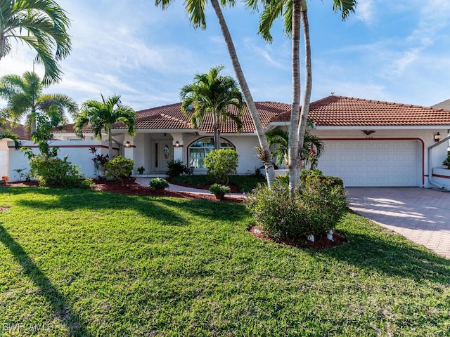 mediterranean / spanish-style home with a garage and a front yard