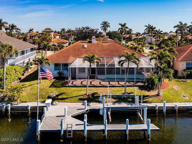 dock area featuring a water view, a lanai, and a lawn