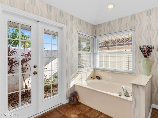 bathroom with tile patterned flooring, a bath, and french doors