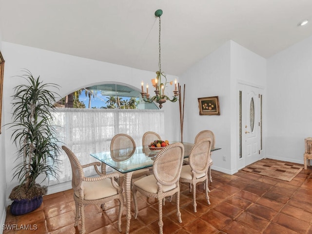 dining room featuring a notable chandelier and vaulted ceiling