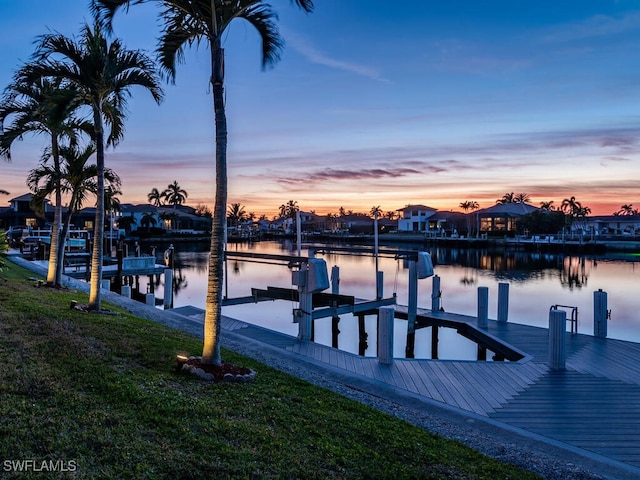 view of dock with a water view and a yard