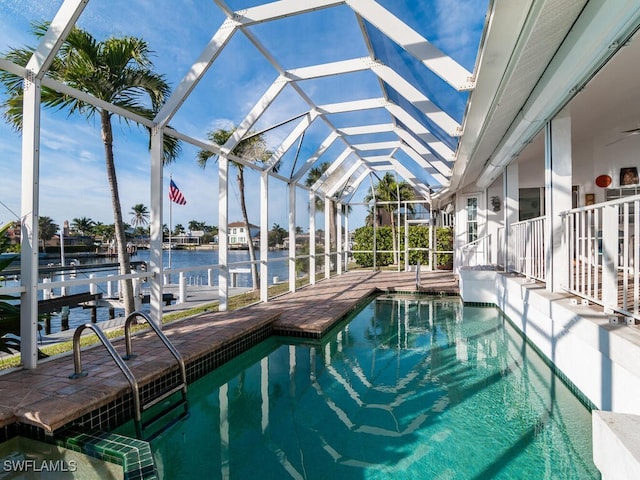 view of pool with a water view, glass enclosure, and a patio area