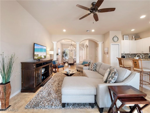 living room with ceiling fan and ornate columns