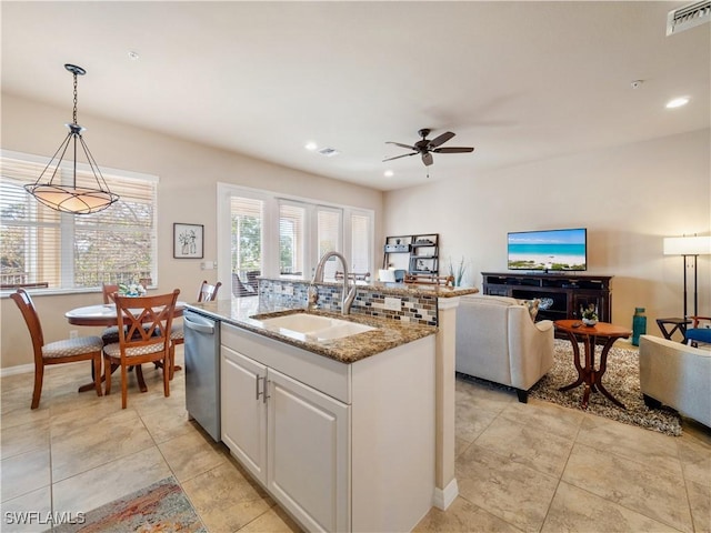 kitchen with pendant lighting, sink, white cabinetry, stone countertops, and stainless steel dishwasher