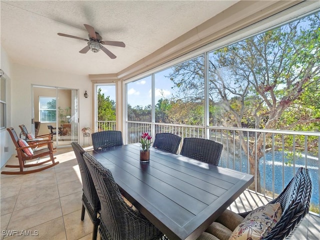 sunroom / solarium with a water view and ceiling fan