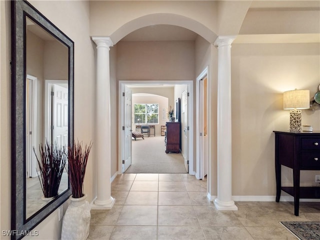 hallway featuring light tile patterned floors and decorative columns