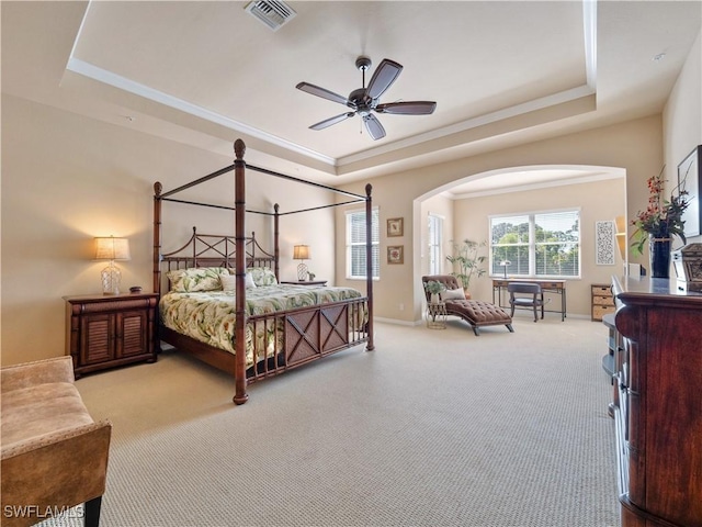 bedroom with ornamental molding, a raised ceiling, and carpet