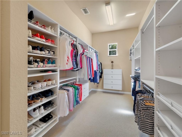 walk in closet featuring light carpet