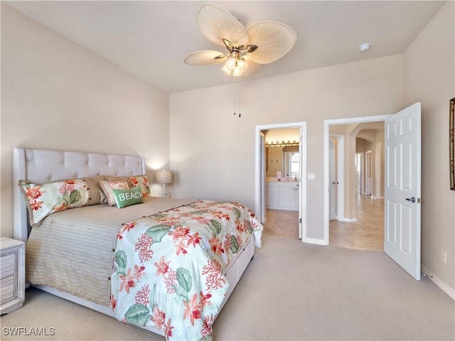 carpeted bedroom featuring ensuite bath and ceiling fan