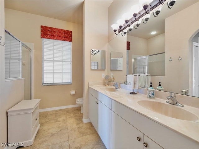 bathroom with tile patterned floors, toilet, a shower with shower door, and vanity