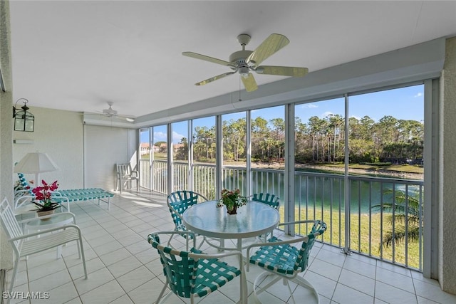 sunroom / solarium featuring a water view and a ceiling fan