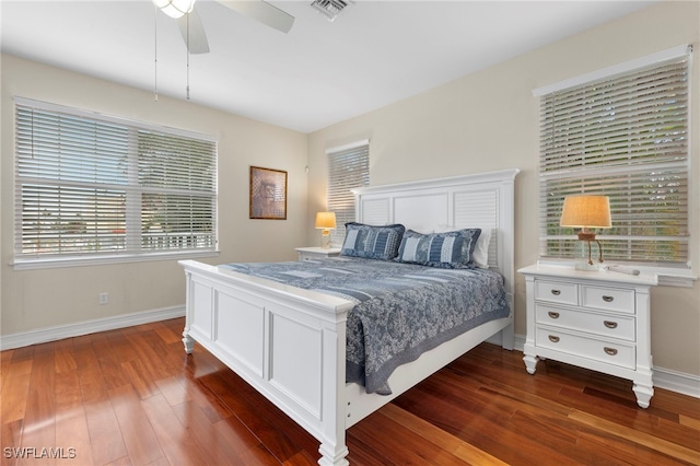 bedroom with visible vents, dark wood finished floors, baseboards, and ceiling fan