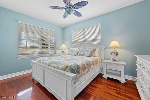 bedroom with ceiling fan, dark wood-type flooring, and baseboards