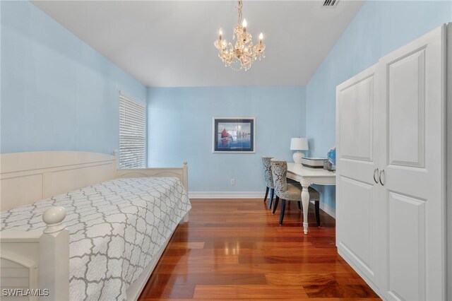 bedroom featuring dark hardwood / wood-style flooring and a chandelier