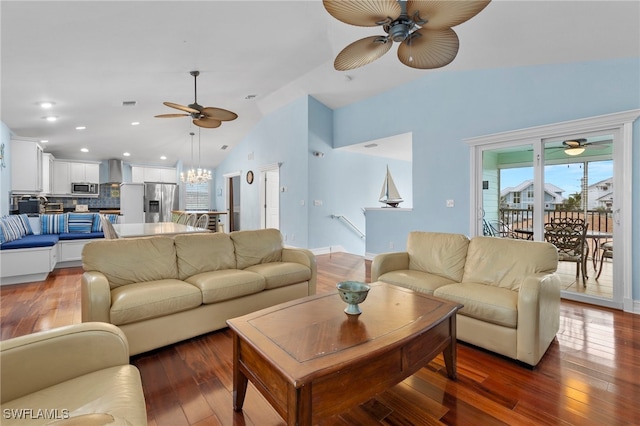 living room featuring lofted ceiling, ceiling fan with notable chandelier, and dark hardwood / wood-style flooring