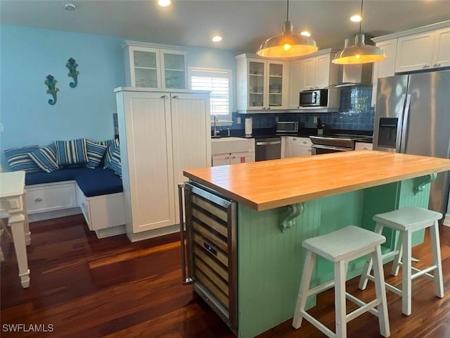 kitchen featuring wine cooler, wooden counters, white cabinets, and a kitchen island