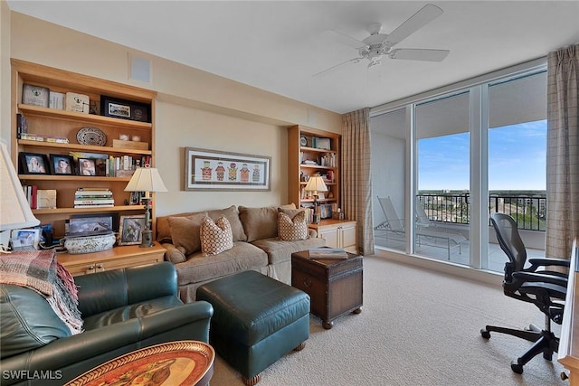 carpeted home office with expansive windows, visible vents, and ceiling fan