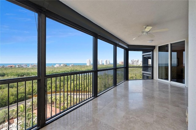 unfurnished sunroom featuring a textured ceiling and ceiling fan