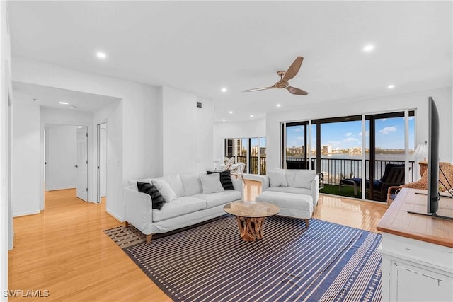 living room featuring light hardwood / wood-style flooring and ceiling fan