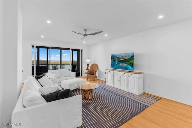 living room with hardwood / wood-style floors and ceiling fan