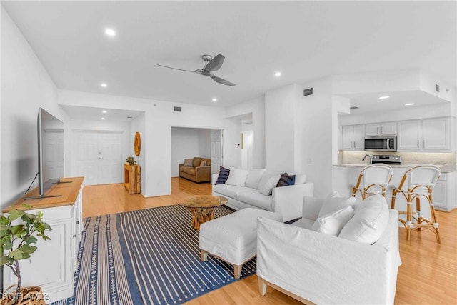 living room featuring ceiling fan and light wood-type flooring